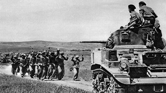 Deutsche, die mit erhobenen Händen vor einem britischen Panzer in Frendj kapitulieren wollen, einen Tag bevor Tunis fällt.