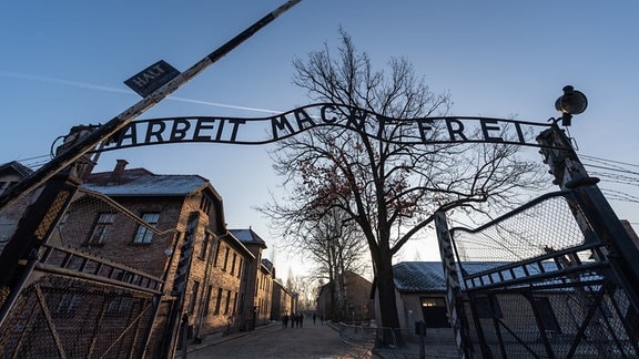Blick auf das Eingangstor des ehemaligen deutschen Konzentrationslagers Auschwitz mit dem Schriftzug 'Arbeit macht frei'