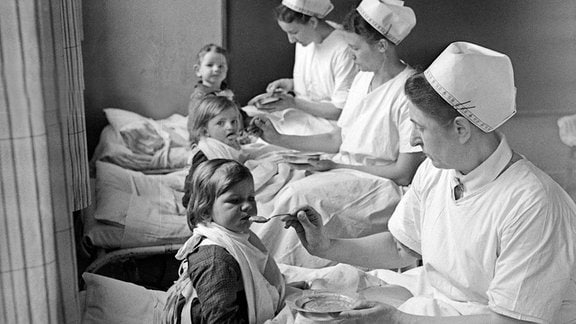 Krankenschwestern füttern Kleinkinder im Mütterheim Dresden auf Schloß Dittersbach