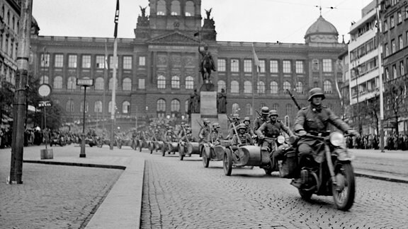 Historische Schwarzweiß-Aufnahme: Einfahrt auf den Wenzelsplatz von SS-Kämpfern auf Motorrädern