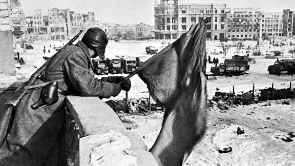 Rotarmist hisst Rote Flagge über Ruinen von Stalingrad 1943