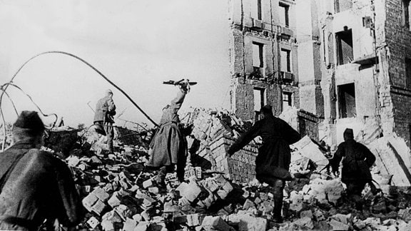 Sowjetische Soldaten laufen durch Ruinen