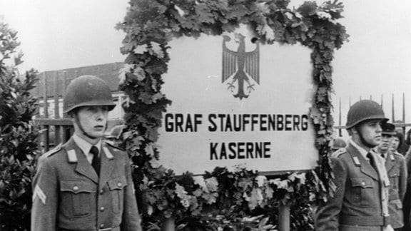 Zwei Soldaten stehen während einer Feierstunde neben dem enthüllten Namensschild der Bundeswehrkaserne in Sigmaringen, die nach dem Widerstandskämpfer Claus Schenk Graf von Stauffenberg benannt wurde.