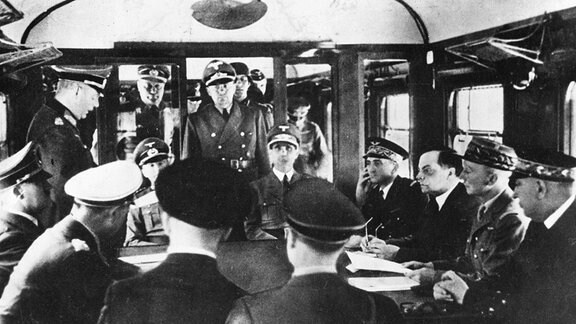 Auf der linken Seite Adolf Hitler, in der Mitte Léon Noël, Marschall Pétains Botschafter in Warschau, auf der linken Seite General Charles Huntziger.