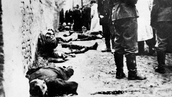 Szene nach der Erschießung von Serben, zeigt Wehrmachtssoldaten im Vordergrund.