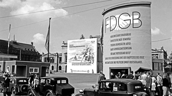 FDGB Plakat, Gewandhaus und Marktplatz in Leipzig. Passanten am Gewandhaus und Marktplatz.