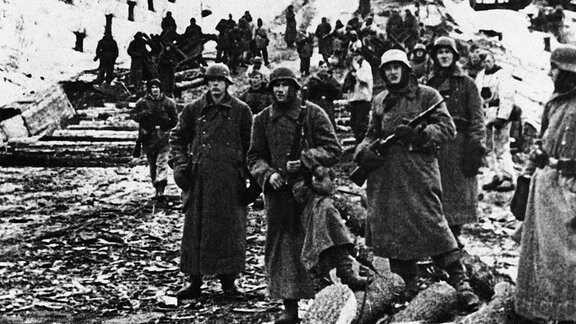 Deutsche Soldaten beobachten während der Kämpfe um Charkow im März 1943 einen Stuka-Angriff auf sowjetische Stellungen.