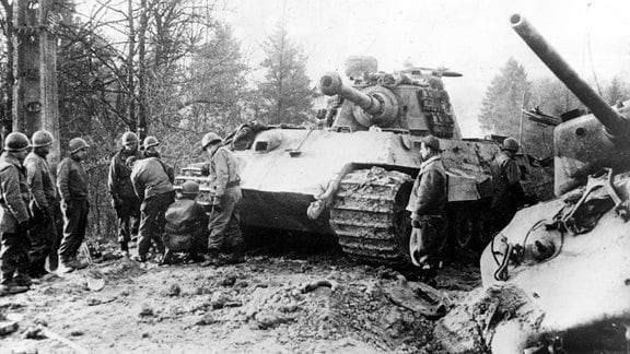US-Soldaten untersuchen liegengebliebenen Panzekampfwagen VI Tiger II Königstiger