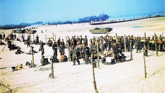 Deutsche Kriegsgefangene hinter Stacheldraht am Omaha-Beach in der Normandie 10. Juni 1944