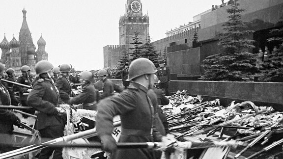 Historische Schwarzweiss-Aufnahme: Rotarmisten werfen Wehrmacht-Standarten vor Kreml zu Boden 1945