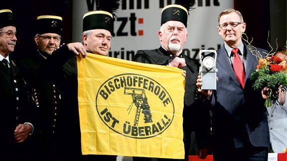 Thüringens Ministerpräsident mit und andere Männer halten eine Bischofferode-Flagge.