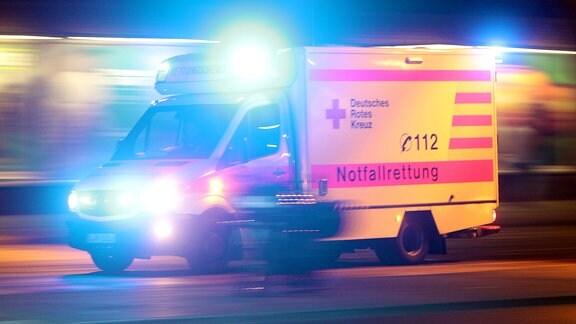 Ein Rettungswagen des Deutschen Roten Kreuzes fährt mit Blaulicht