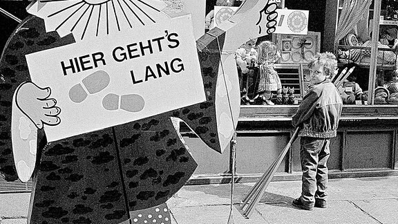 Ein Junge vor einem Schaufenster in der DDR.