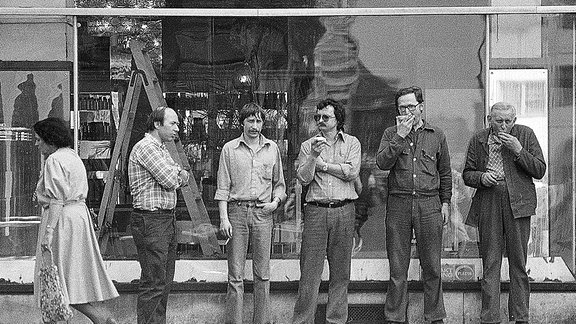 Männer stehen vor einem Schaufenster eines Lampenladens, in der DDR.