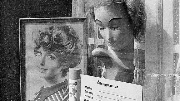 Blick ein ein Schaufenster eines Frisörladens in der DDR.