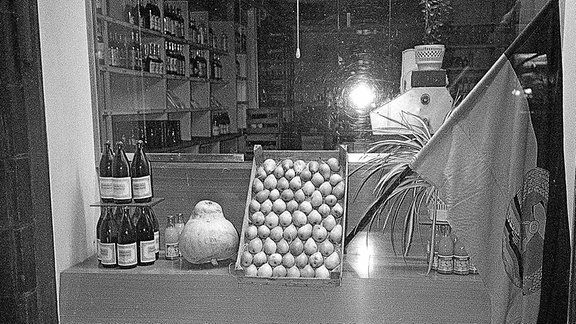 Blick durch ein Schaufenster eines Lebensmittelladen in der DDR.