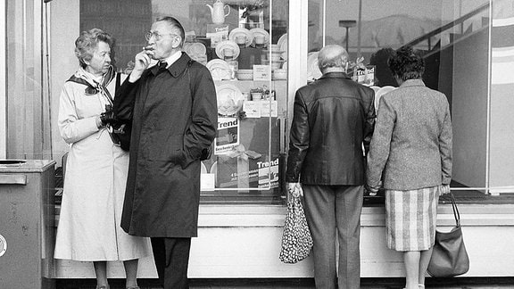 Menschen vor einem Schaufenster in der DDR.