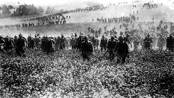 Deutsche Infanterie marschiert 1914 in Frankreich ein. Soldaten rücken auf einem Feld vor.