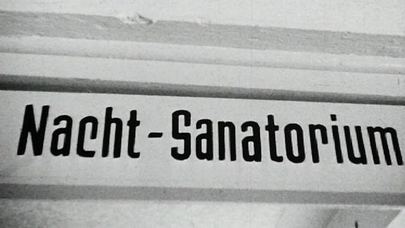 Alte Schwarzweißaufnahme: Schild mit Aufschrift "Nacht-Sanatorium"