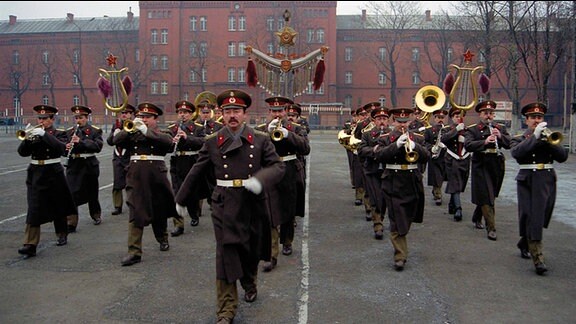 Russische Soldaten marschieren auf einem Platz.