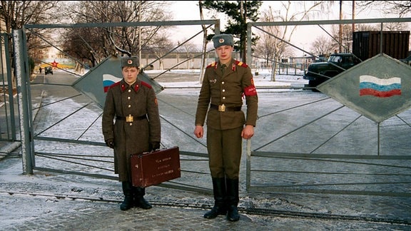 Russische Soldaten stehen vor einem Tor.