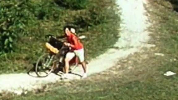 Kuba, eine Frau schiebt ein Fahrrad.