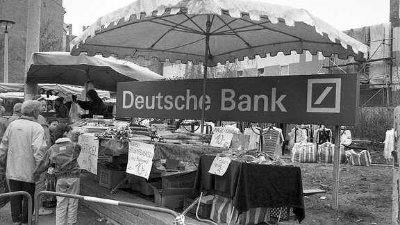 Blick auf einen Schnäppchenstand vor einem Werbeplakat