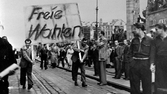 Aufstand des 17. Juni 1953 in Ostberlin. - Demonstranten tragen Plakate mit der Forderung nach freien Wahlen durch die Strassen.