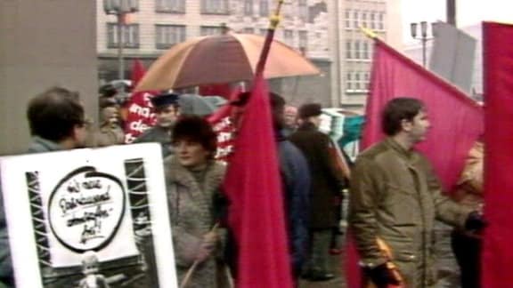 Um den Blick auf die Plakate der Bürgerrechtler zu versperren, hielten Stasi-Leute schnell Plakate für eine atomwaffenfreie Welt empor…