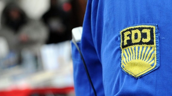 Ein FDJ-Aufnäher auf einem blauen Hemd