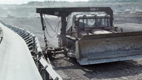 Raupe richtet im Tagebau Goitzsche Förderband für Kohle aus