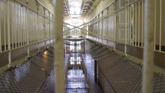 Ein Gefängnis im Inneren mit Zäunen und Fluren.
