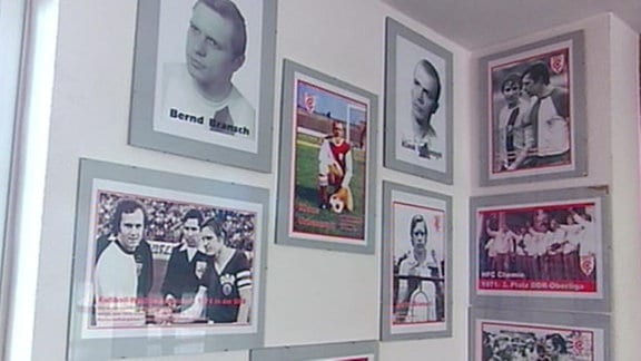 Gerahmte Bilder mit historischen Fußballaufnahmen an einer Wand