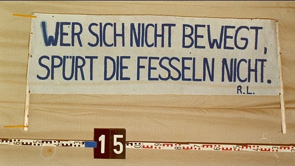 Plakat mit dem Zitat: "Wer sich nicht bewegt, spürt seine Fesseln nicht"