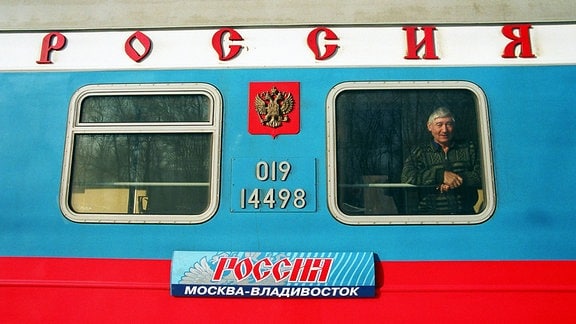 Ein Reisender am Fenster eines Waggons der Transsibirischen Eisenbahn