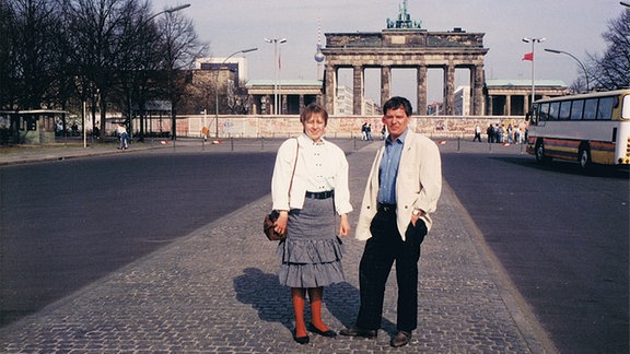 Ein Mann und eine Frau stehen 1985 vor dem Brandenburger Tor in Westberlin