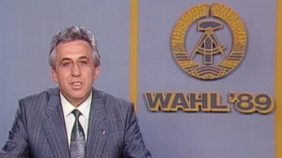 Egon Krenz in einem Fernsehstudio mit DDR-Emblem und Schriftzug Wahl '89