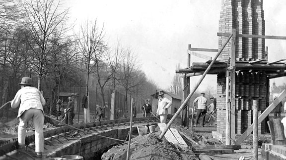 Auf einer Baustelle im Zoo Leipzig heben Bauarbeiter einen Graben aus.