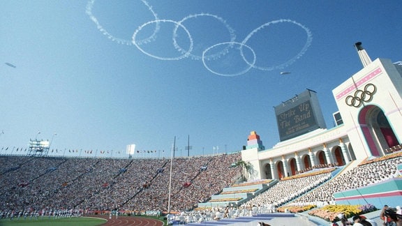 Während der Eröffnungsfeier der Olympischen Spiele 1984 in Los Angeles stehen die Olympischen Ringe am Himmel über dem ausverkauften Olympiastadion