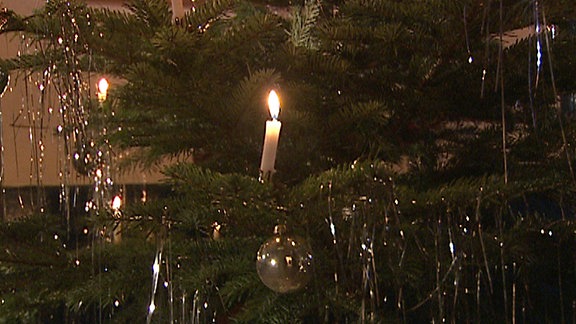Kerzen brennen an einem Weihnachtsbaum