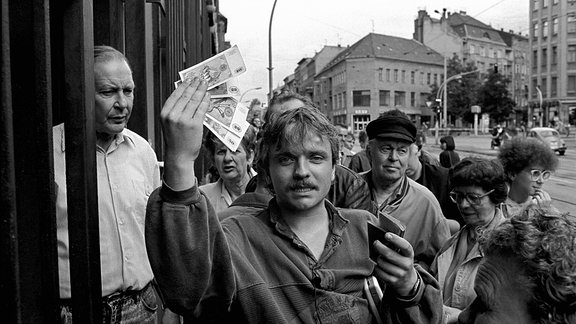 Tag der Währungsunion Deutschland, Berlin, 01.07.1990, Mann mit D-Mark und DDR Ausweis.
