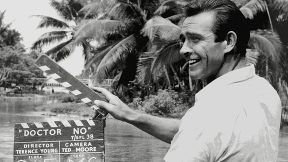 Sean Connery als James Bond Dr. No (1962) schlägt eine Filmklappe