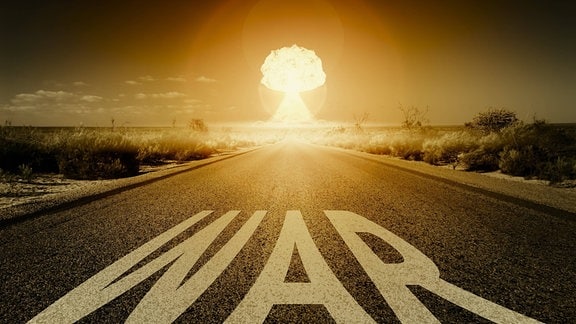 Eine Explosion einer Atombombe am Ende einer Strasse mit der Aufschrift War.