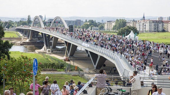 Bei der Eröffnung der Dresdner Waldschlößchenbrücke laufen menschen über die Brücke.