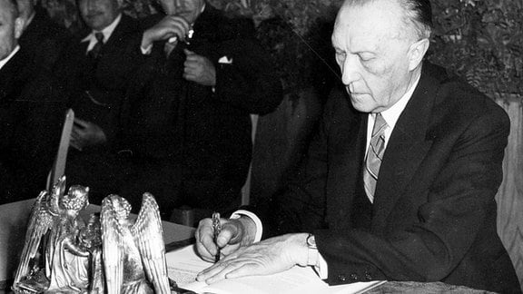 Unser Archivbild zeigt den Praesidenten des Parlamentarischen Rates, Dr. Konrad Adenauer, bei der Unterzeichnung des Grundgesetzes am 23. Mai 1949 genau um 17 Uhr in Bonn. 