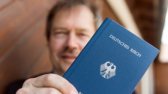 Reichsbürger Joachim Widera posiert 2016 in Rheinfelden (Baden-Württemberg) mit seinem "Deutsches Reich Reisepass" für den Fotografen. 
