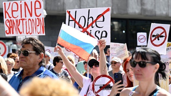 Eine Teilnehmerin einer pro-russischen Kundgebung hält eine russische Fahne.