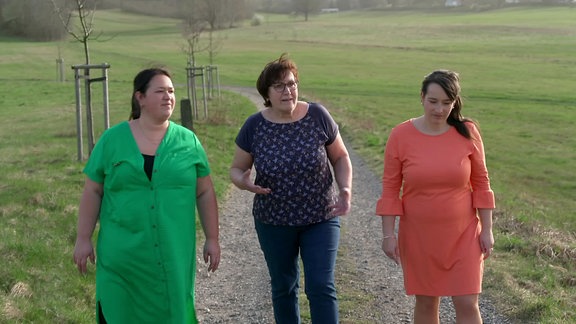 Drei Frauen laufen nebeneinander her.