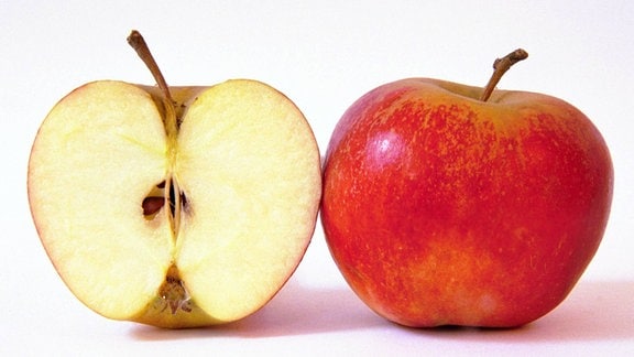 ein aufgeschnittener Apfel neben einem ganzen