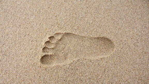 Ein Fußabdruck im Sand.